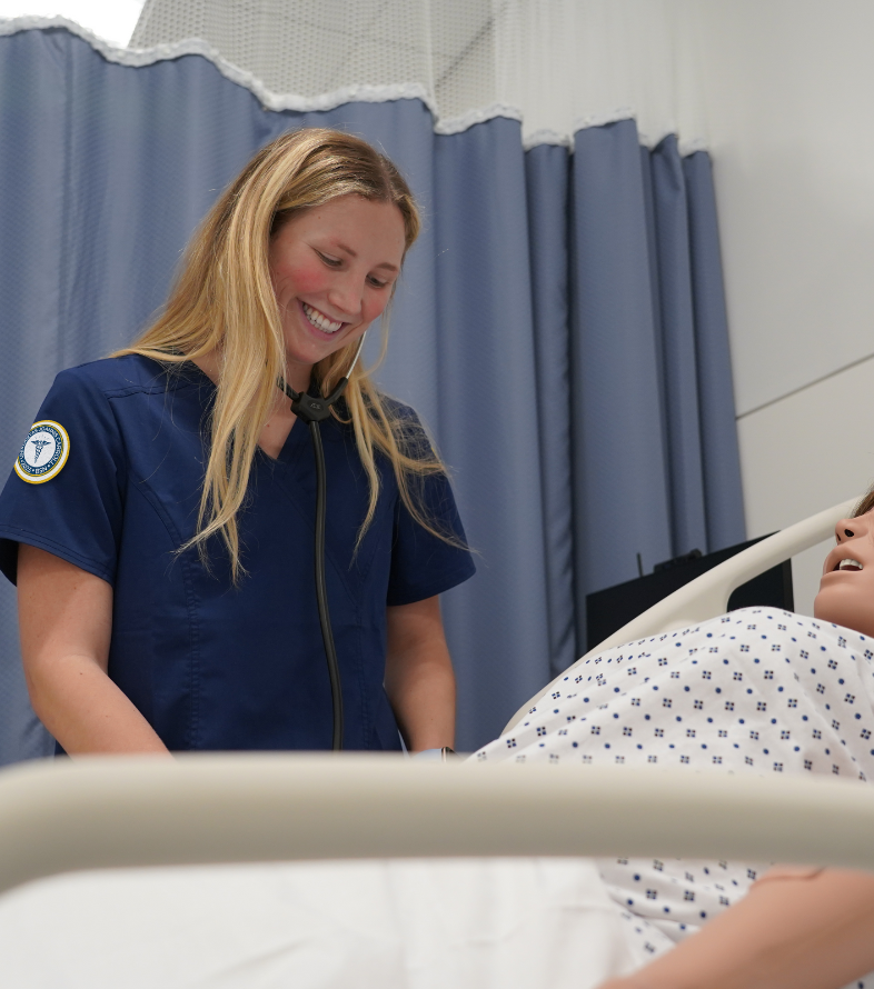 jcu female nursing student practicing heart monitor on medical manniquin