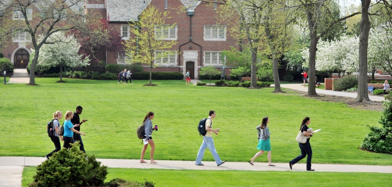 Students walking across campus on a spring day